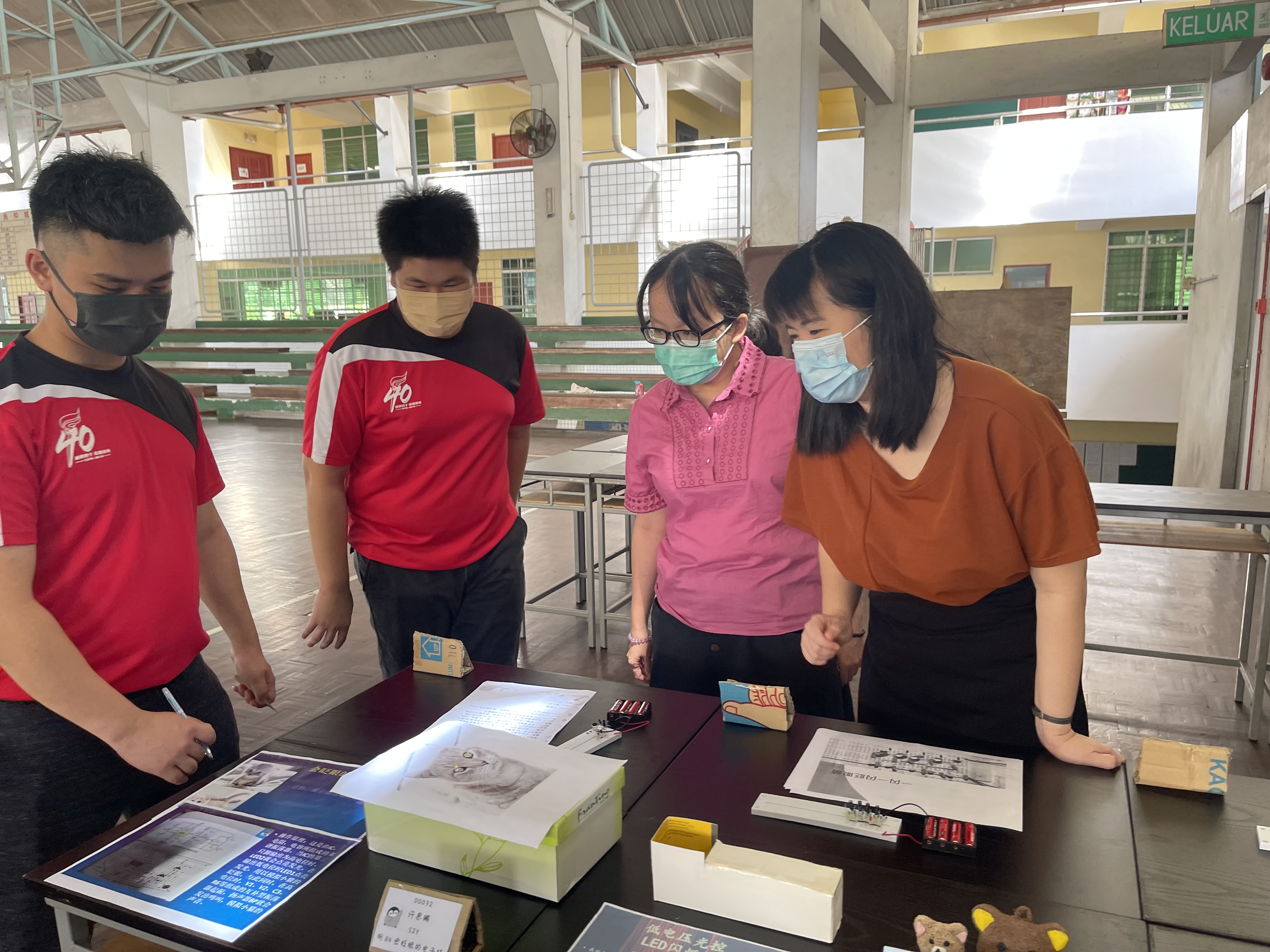 導覽員給老師講解電子作品