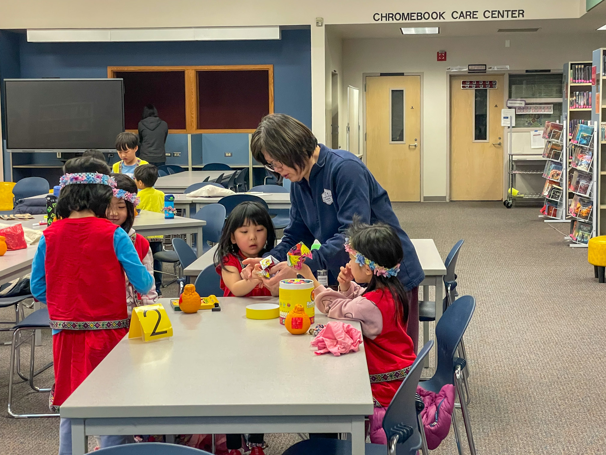 校長指導小朋友在橘子上貼上自己寫的【吉】【福】字送給爺爺奶奶。