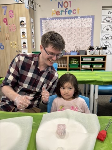 孩子分享爸爸學華語的成果，展現家庭共同學習的溫馨時刻。