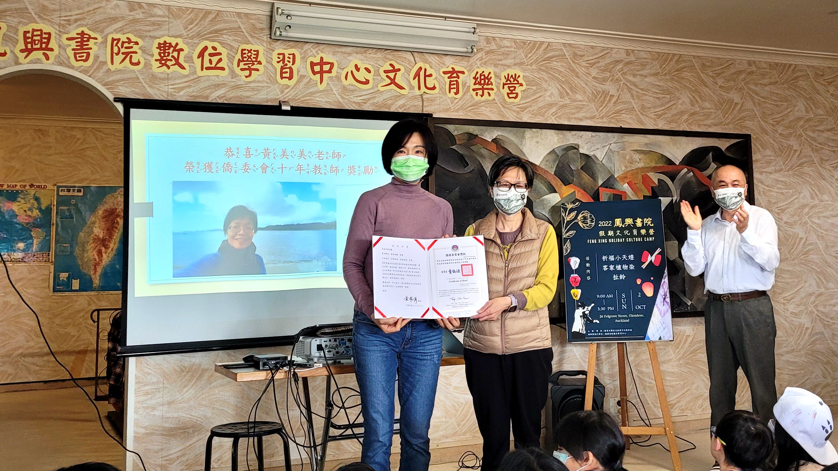 駐奧克蘭辦事處僑務組長邱亞芬（左）頒發黃美美老師（右）十年教師獎勵