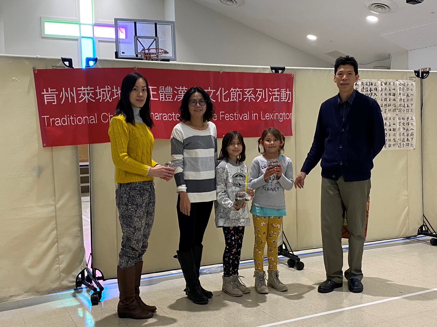 書法老師和校長頒發獎品給書法比賽獲勝的國小組學生