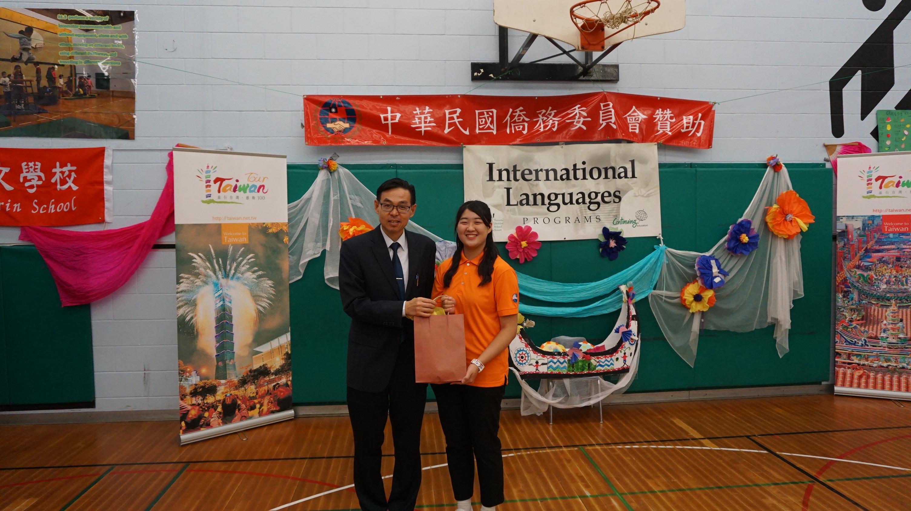 文教中心孫國祥主任致贈海華文教基金會暑期華語教學4位志工代表禮物。