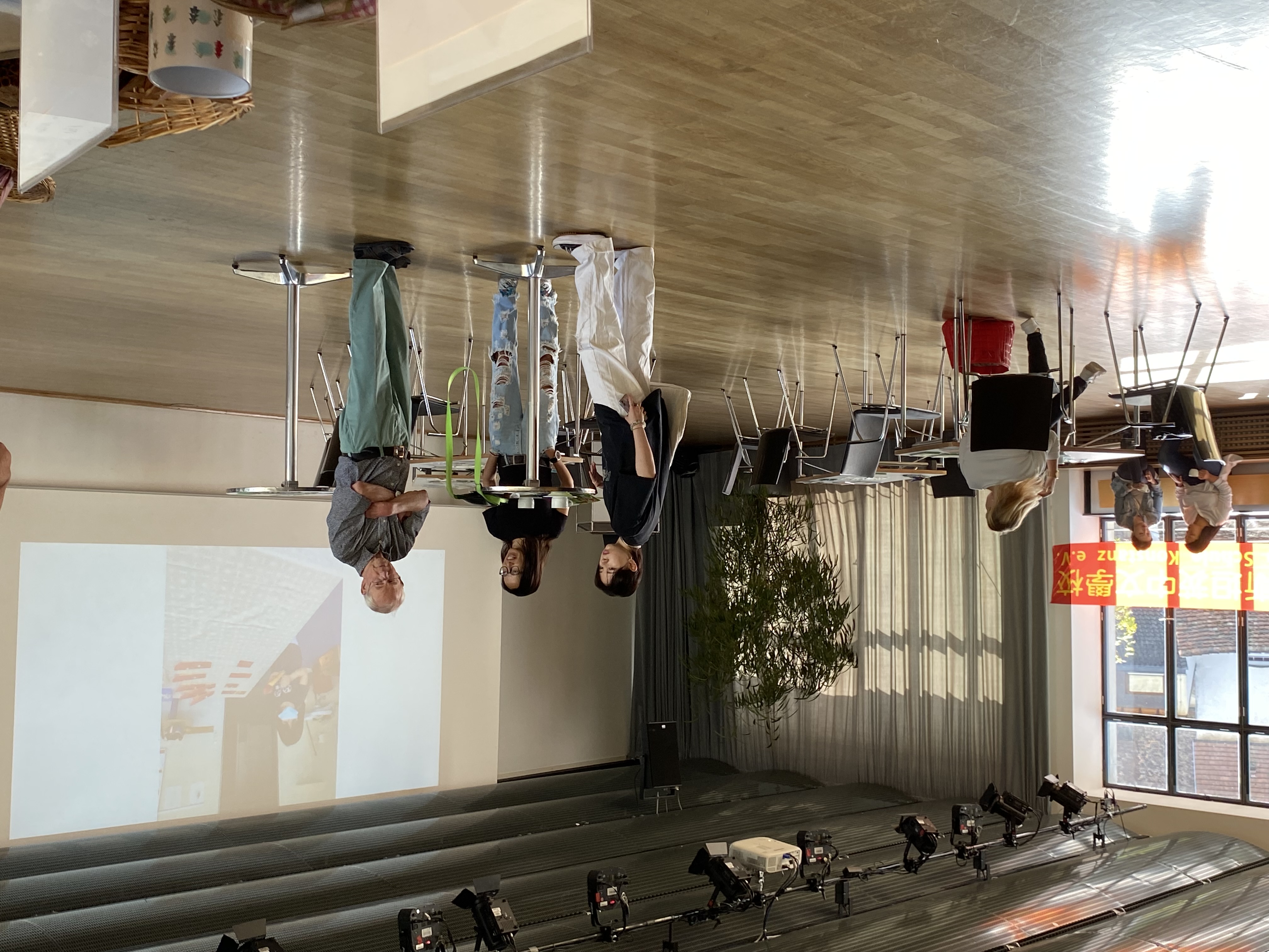 訪客交流。螢幕上投影片播放學校創校迄今所有活動照片。