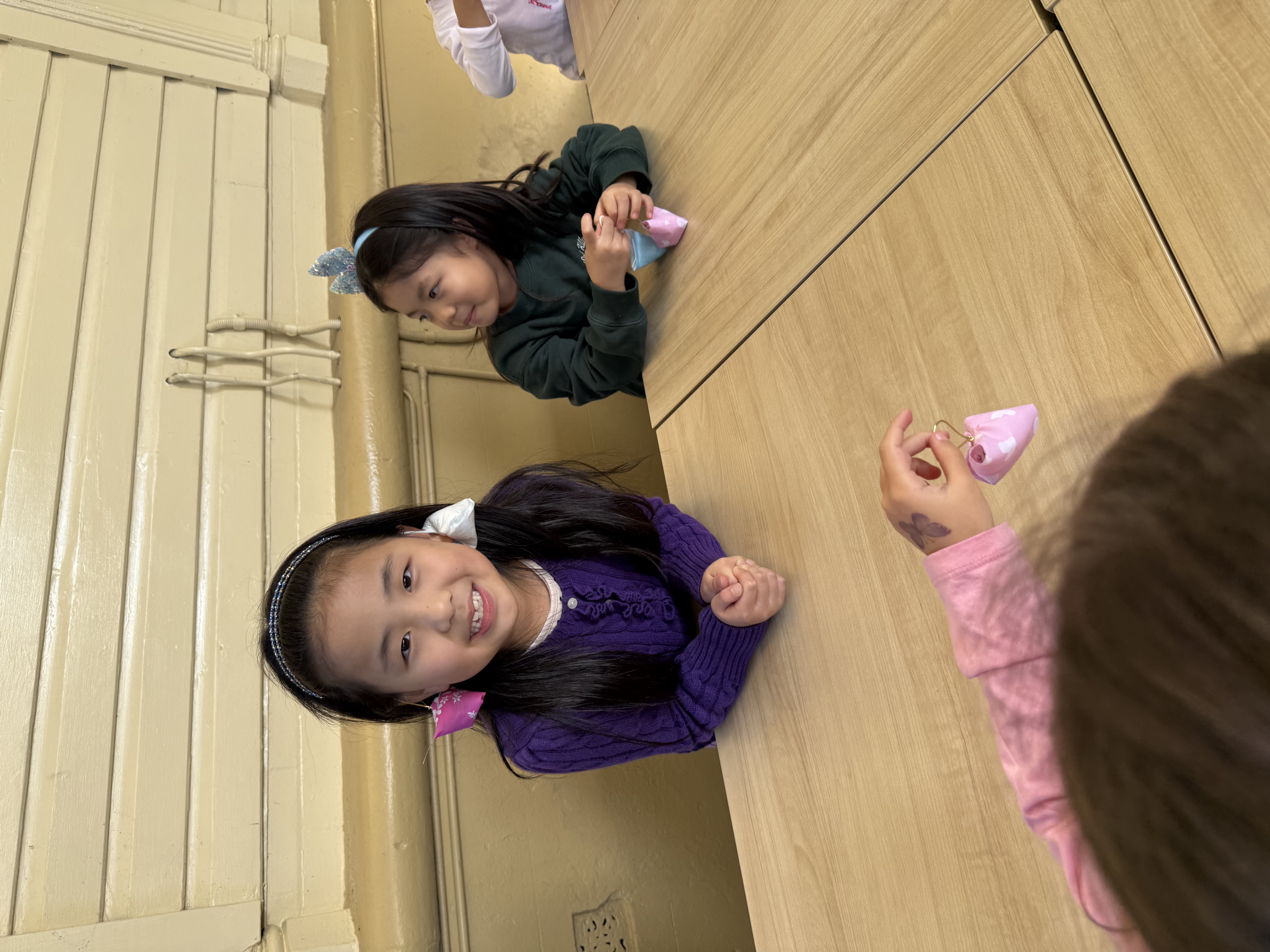 小朋友很有創意的把香包掛在耳朵上，當耳環載，煞是可愛