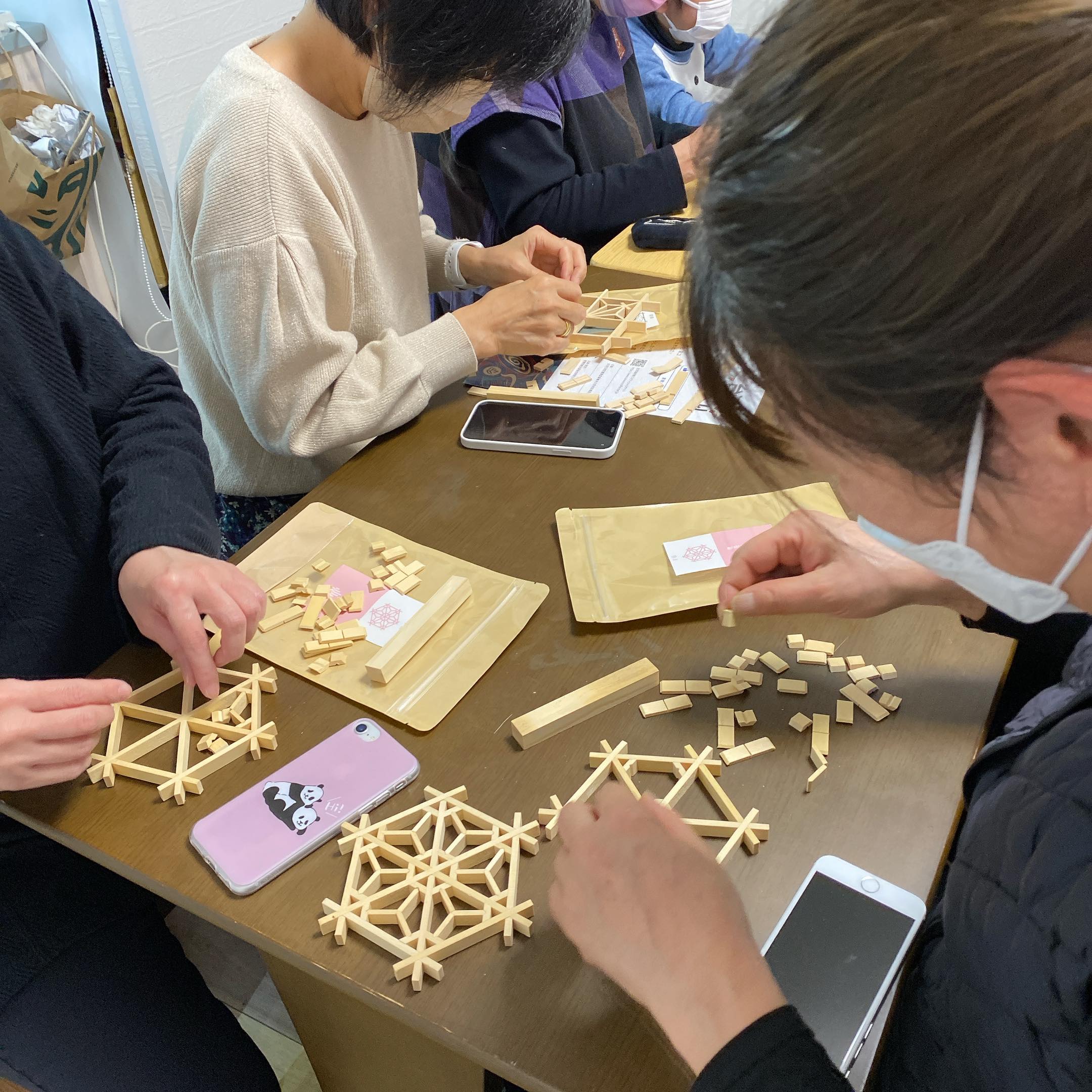 參加者們體驗組合木花窗的杯墊