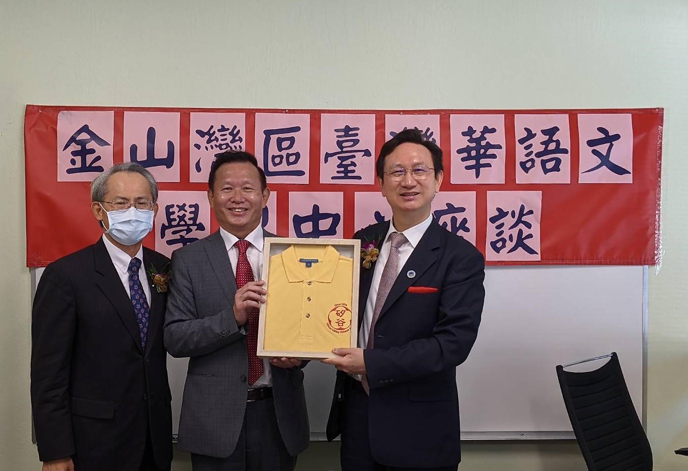 寇惠風校長向童振源委員長致贈矽谷中文學校紀念校服，左側為駐舊金山臺北經濟文化辦事處賴銘琪處長