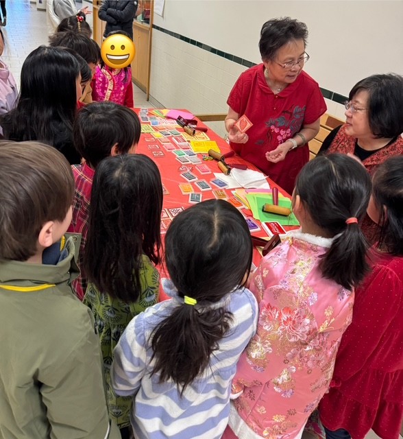 許淑芬老師(後左) 教導小朋友用拓印藝術來設計新年賀卡。