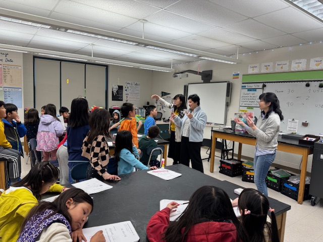 老師拿出臺幣和美金的便條紙讓小朋友看上面的圖案。