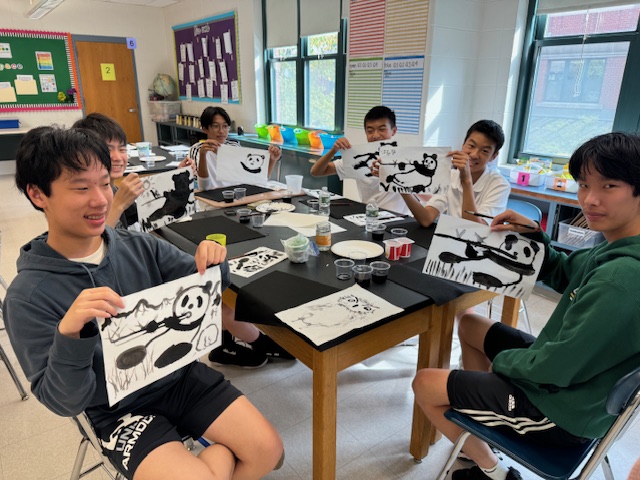 九年級的男同學展示自己所畫的貓熊作品