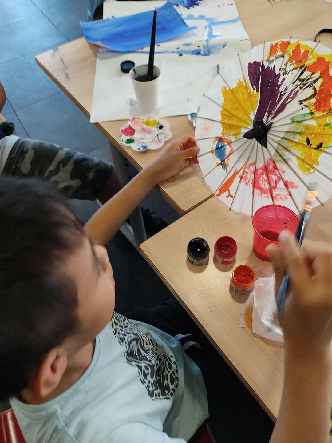 法國亭林中文學校於7月11日舉辦為期6天的夏令營活動，圖為學員體驗彩繪紙傘。
