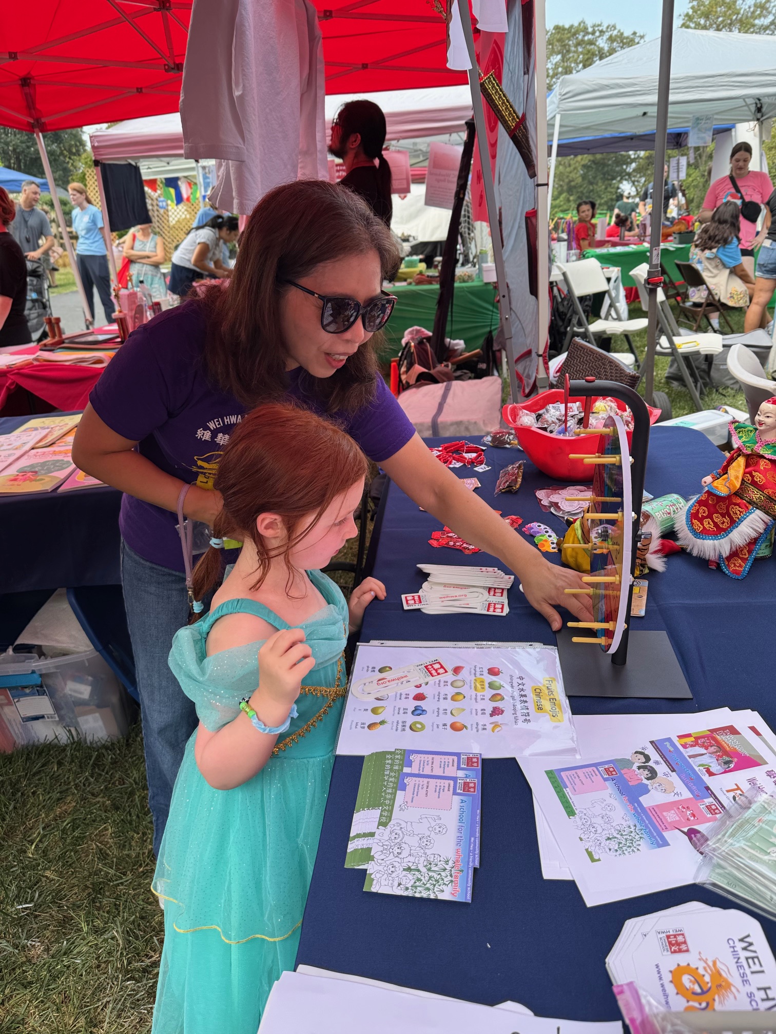 維華校長親自與一位正在參加語言遊戲的小朋友互動，孩子專注投入學習中文，場面溫馨有趣。