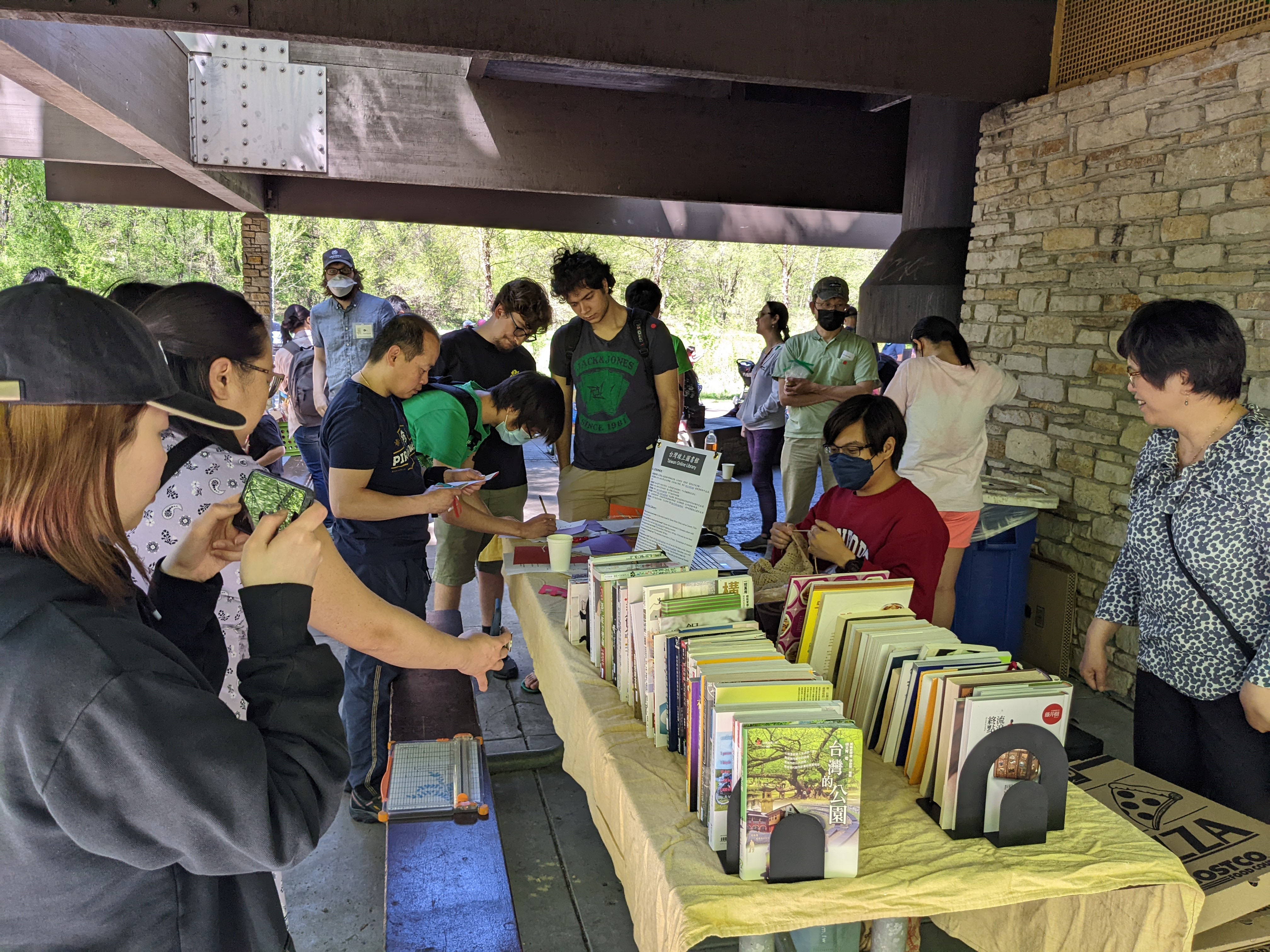 大家圍著書攤看書，有的玩剪紙！