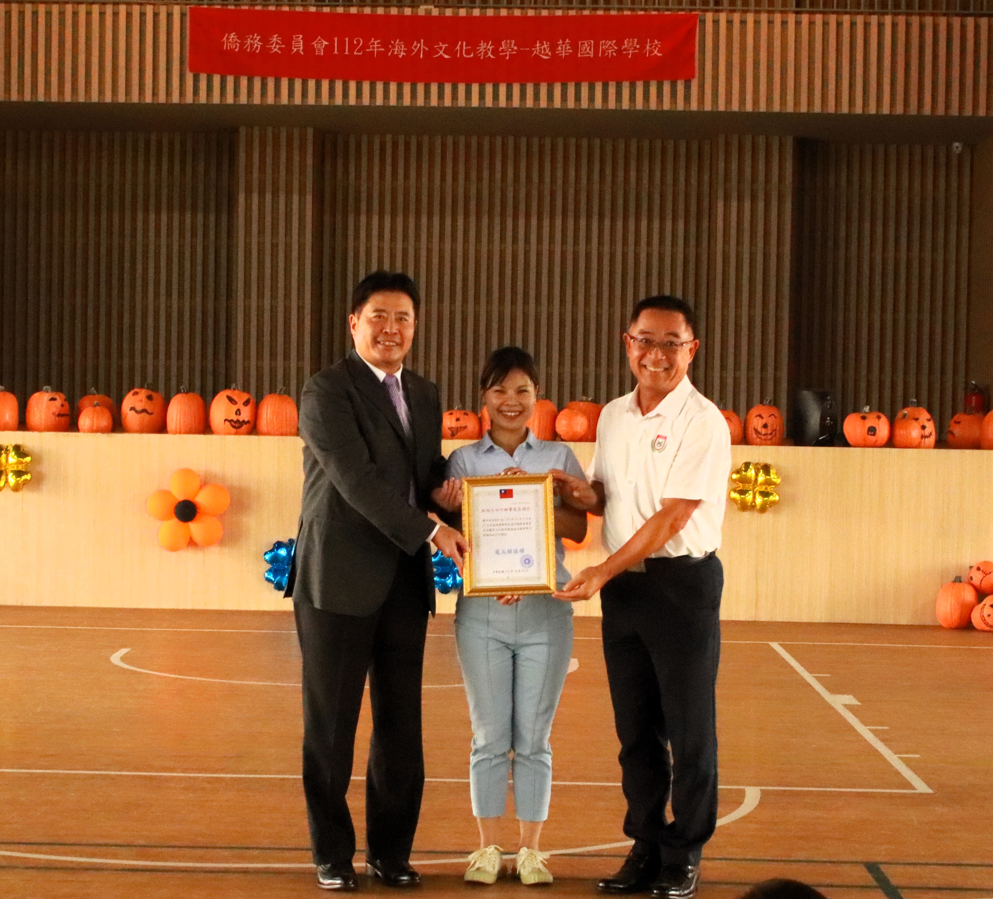 駐胡志明台北辦事處僑教組張皓鈞組長致贈感謝狀，越華謝明輝董事長也共同合影