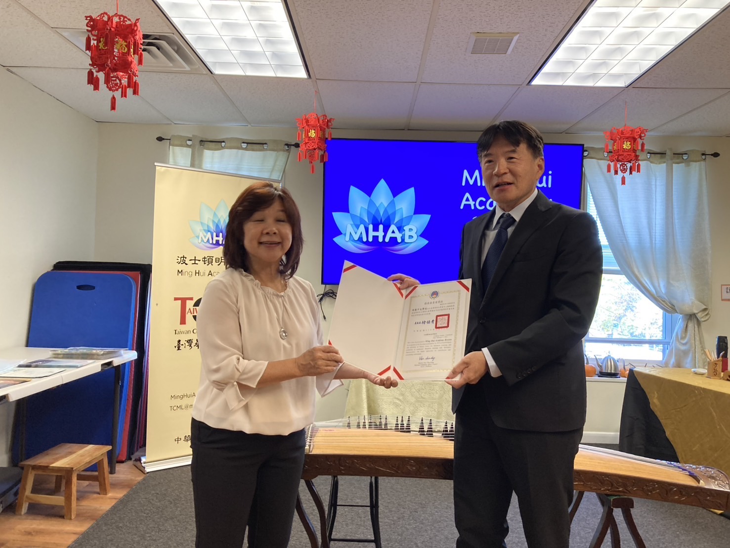 高家富主任（右）致贈劉珊玲校長（左）表揚狀，讚許明慧學校學成功