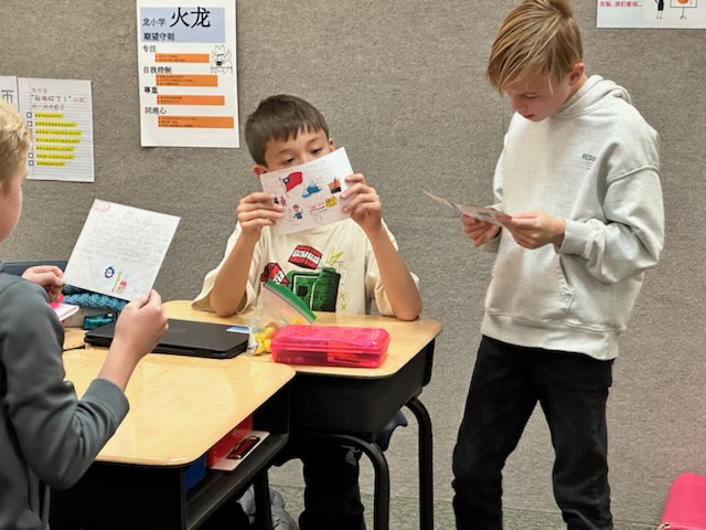 猶他州德柏國小同學專心閱讀北市再興小學同學寄來的交流卡片