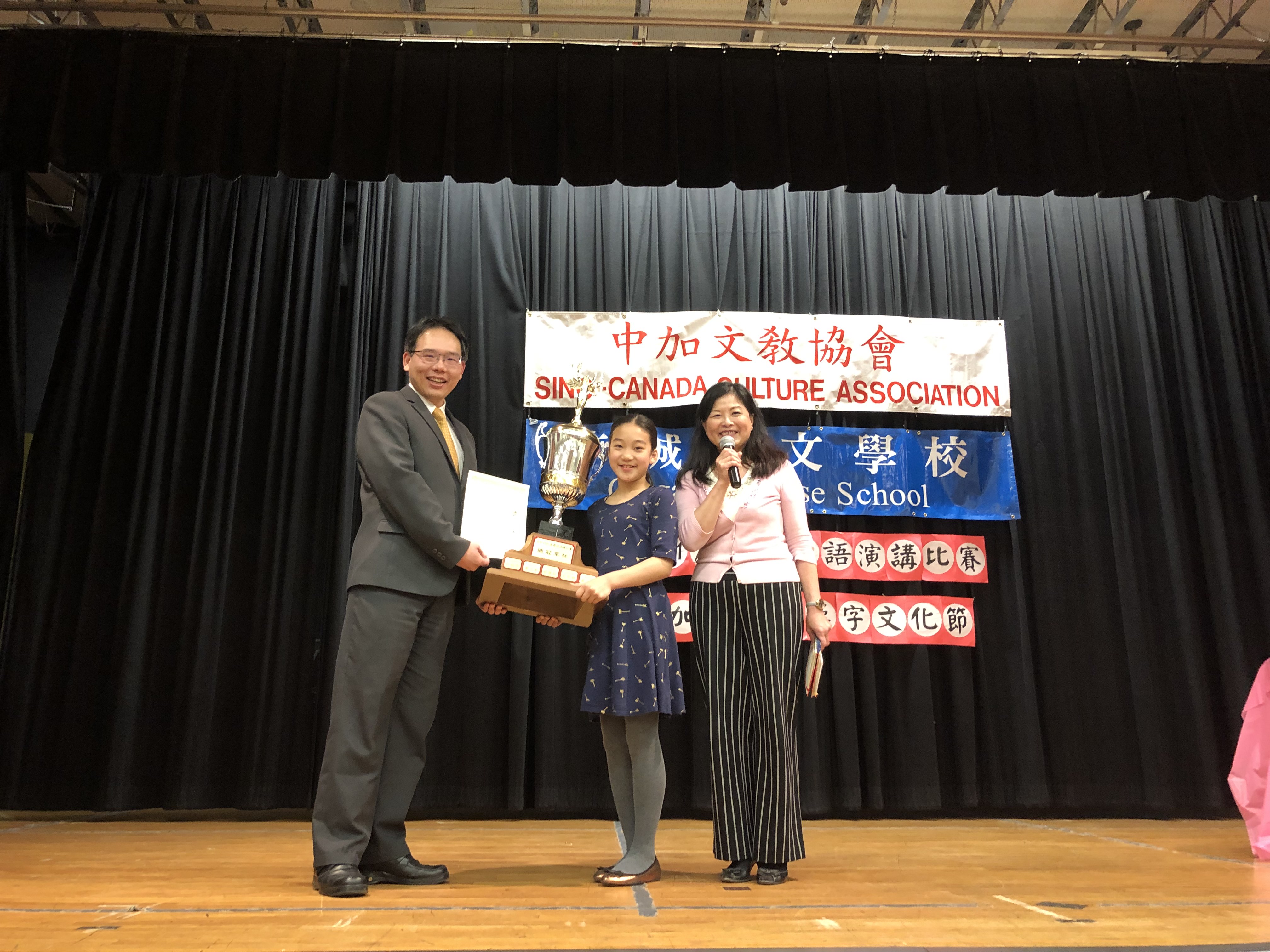 夏基陸（左）頒發國語演講比賽總冠軍將盃給石洛桐（中）。