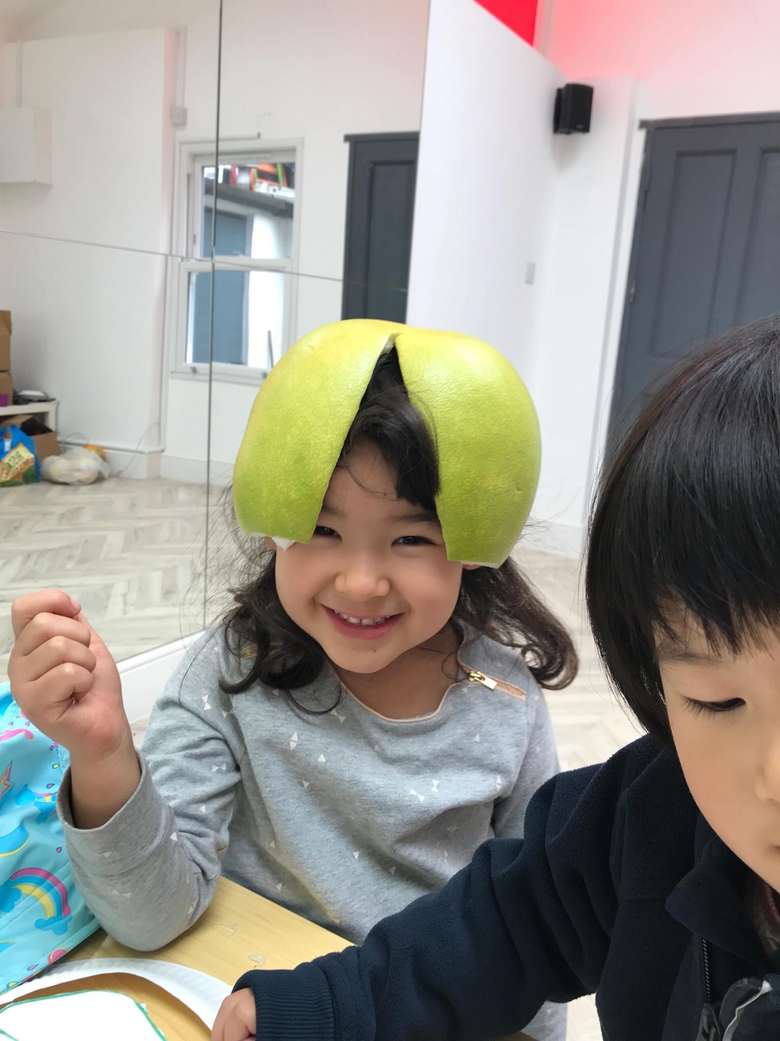 小朋友學會把柚子的皮當做帽子,戴在頭上，非常有趣！