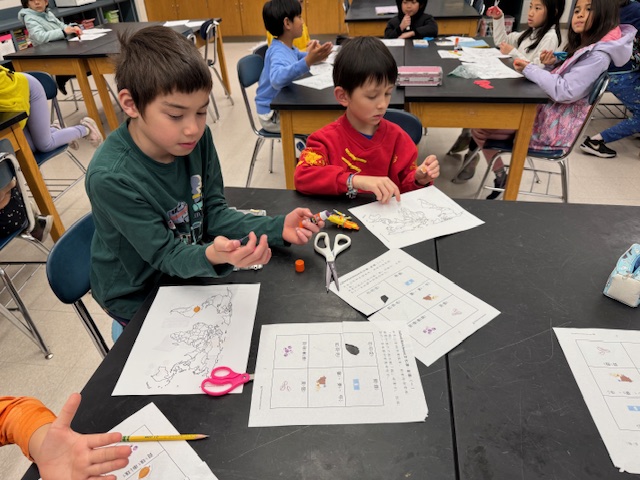 認識古早以物換物的交易工具，陳老師讓小朋友用手作方式增加學習效果。