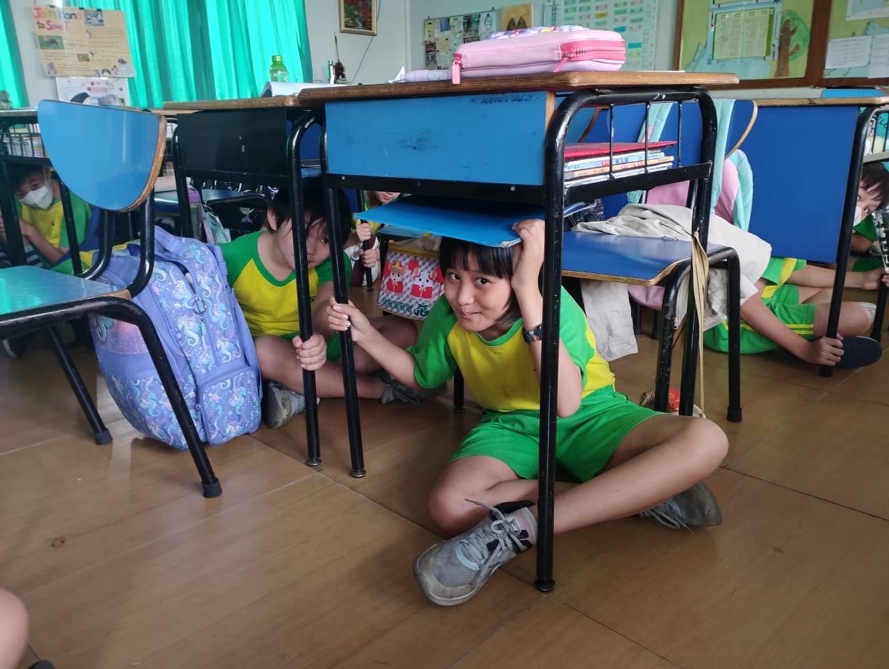 學生於課桌椅下進行掩蔽
