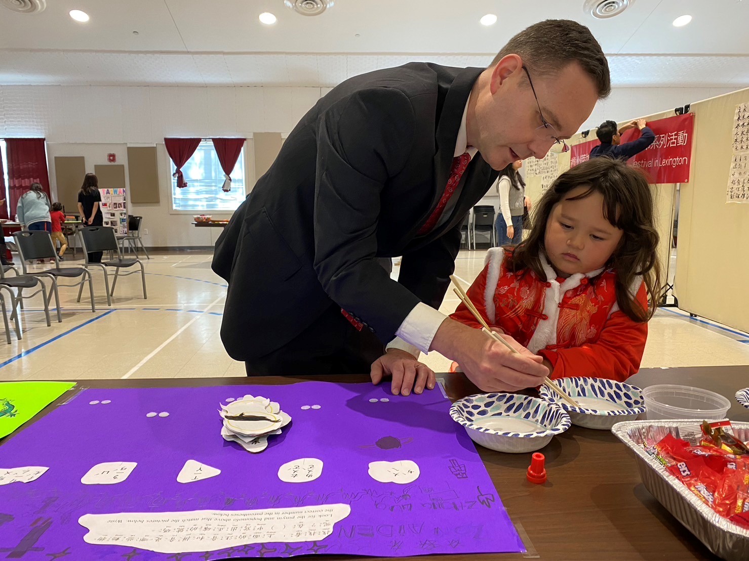 家長（也是學生）和孩子在練習用筷子