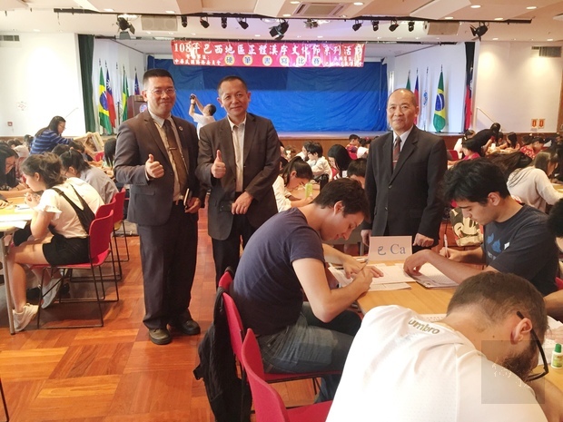 張崇哲(立者中)、詹前校(立者左)與林志孟(立者右)巡視考場，為參加者加油打氣。