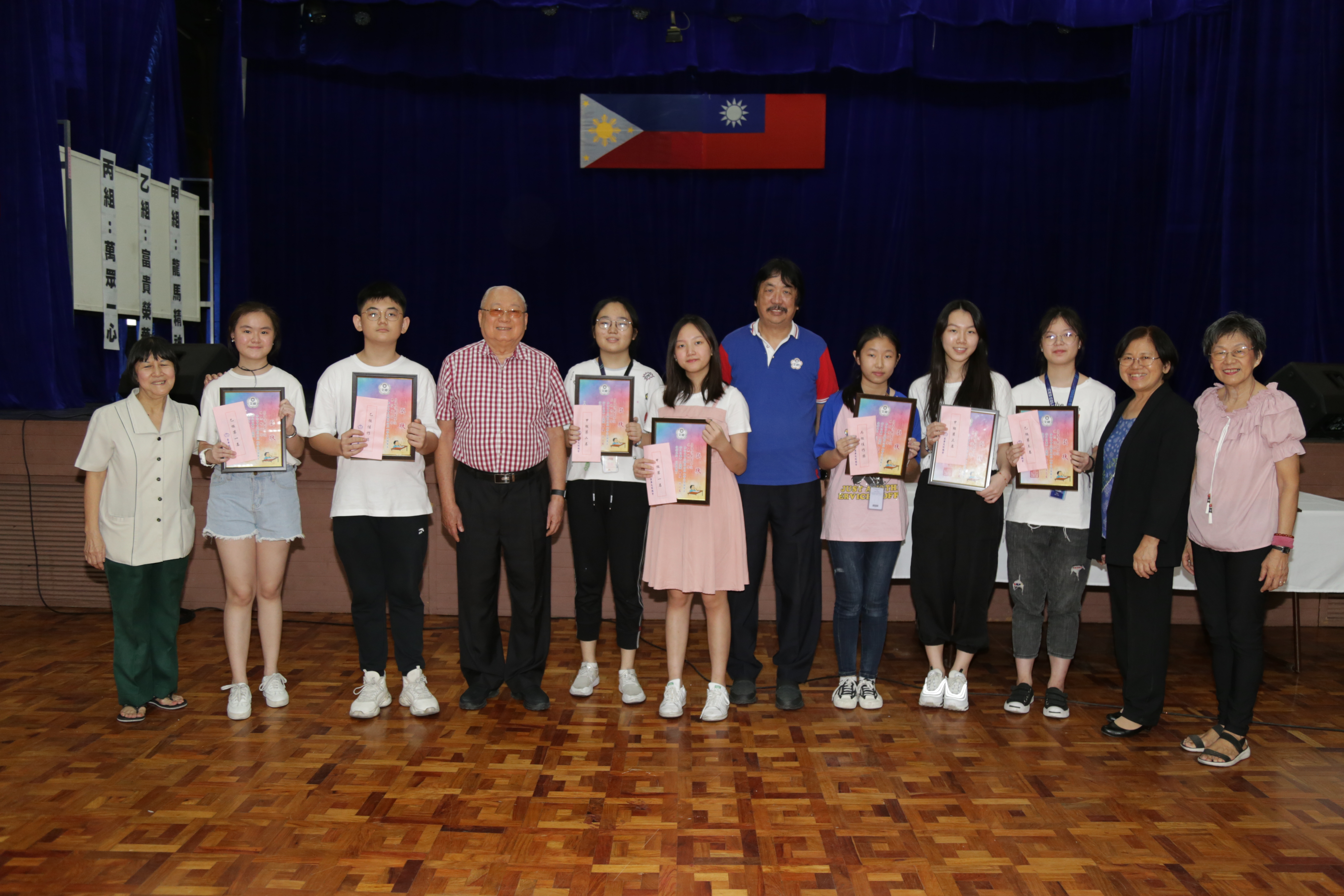 本會蔡秘書長錦郎﹝左四﹞、蔡副秘書長兼文化工作委員會主任懷強﹝右六﹞、文總教師聯誼會陳會長錦芬﹝右二﹞、李副會長如好與菲律濱中正學院獲獎之學生及指導老師合影留念。