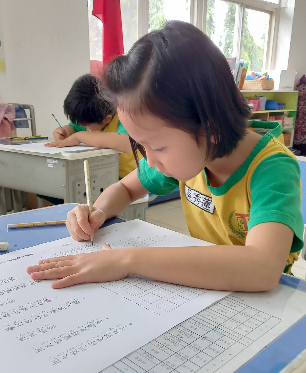 小朋友聚精會神地寫字，筆畫清楚，字體端正。