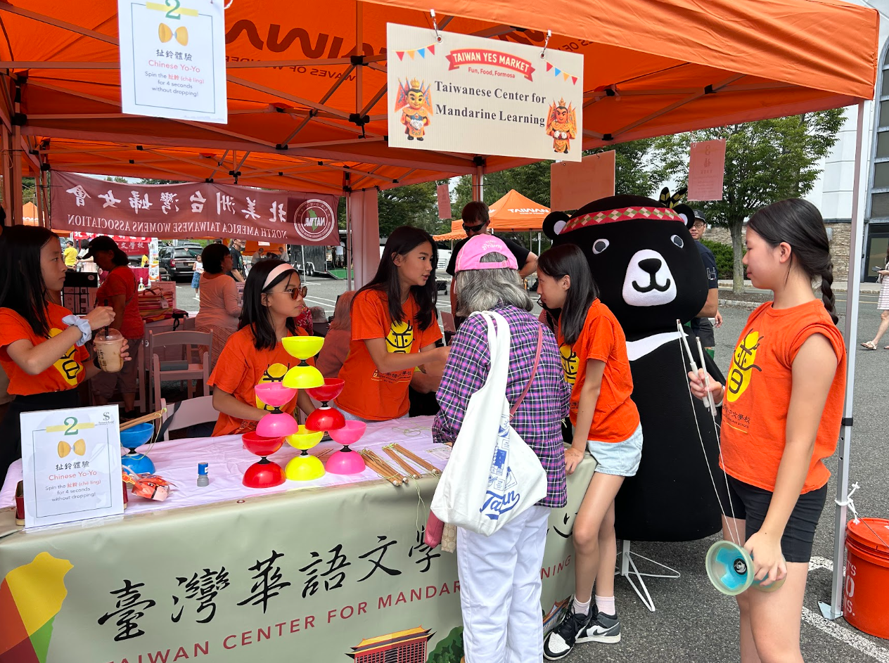 TCML攤位的小義工們準備就緒，示範傳統技藝與華語互動，吸引民眾。 