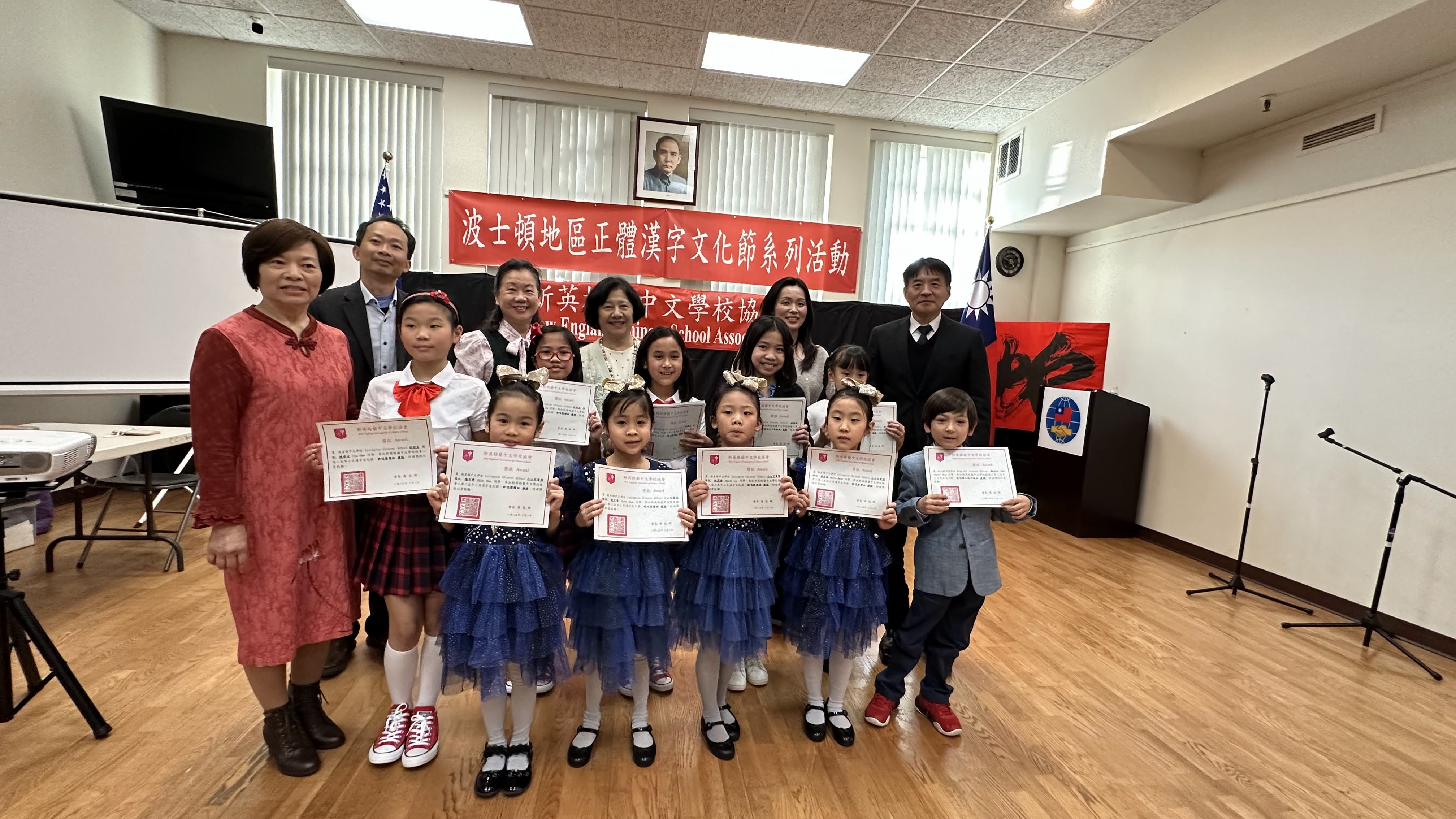 波士頓文教中心高家富主任（後右一）、新英格蘭中文學校協會會長黃冠群（後左一）、評審吳萍萍、馮文鸞、顏毓芬 （後左二，三，四）、主持人王月娥（前左一）及歌唱比賽優勝同學合影。