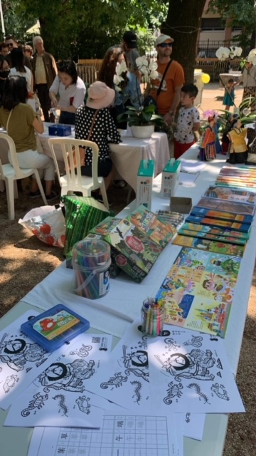 園遊會入場票口。感謝僑務組提供正體華語文教材及布袋戲玩偶。好事花生工作坊著色圖型設計和正體字練贊助商品，台灣OKIDLAND蘭花公司贊助商品，台灣設計台灣製造QBI磁性積木軌道車組贊助商品