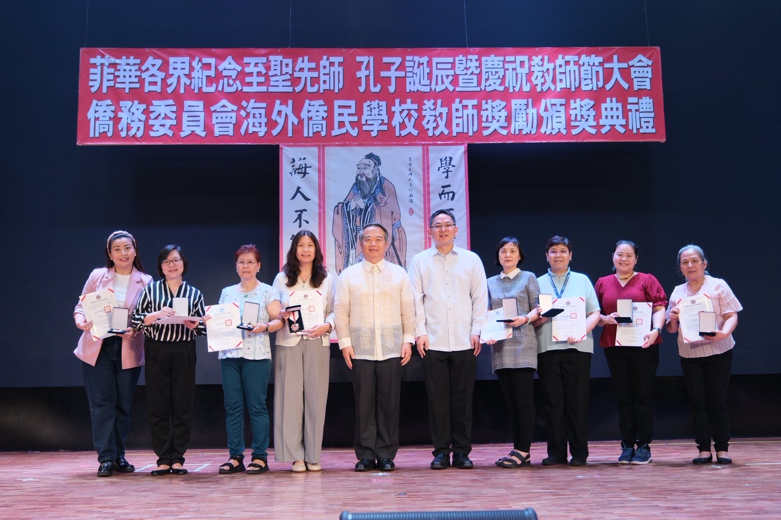 大使周民淦頒贈獎座給執教資深優良教師，菲華文教服務中心主任莊博智同臺見證