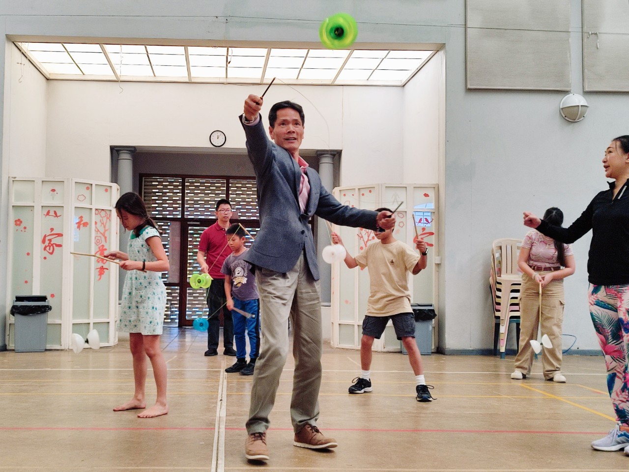 張世佑(中)在黃曉玲(右)指導下展示扯鈴