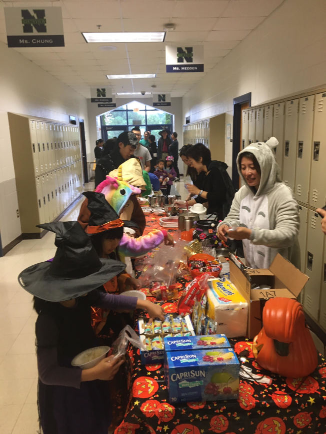 學生們排隊領取熱心家長準備的節日豐富點心及糖果。(台灣學校提供)