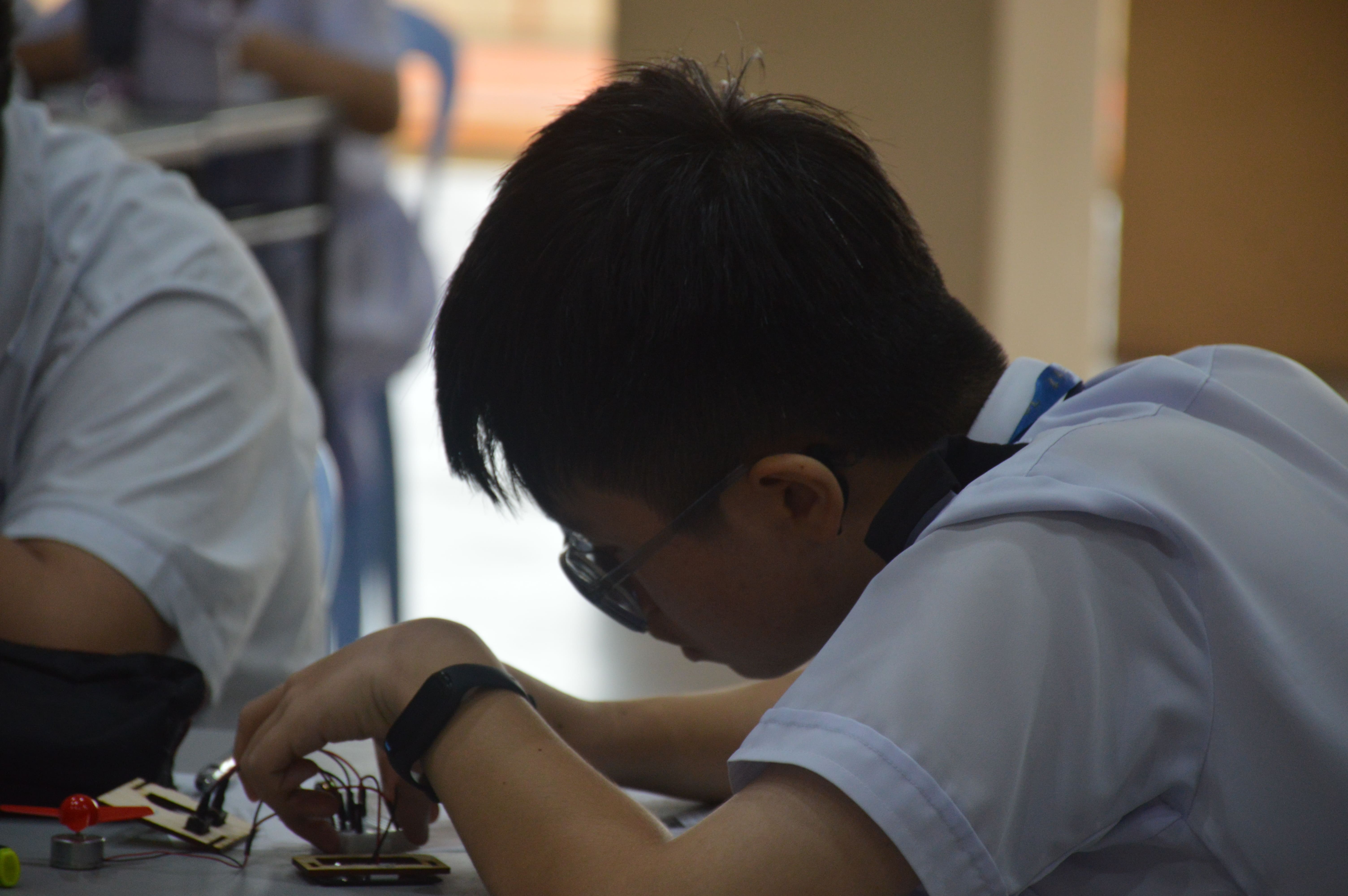 學生認真學習電路、製作屬於他們的第一個節能智慧光電小屋