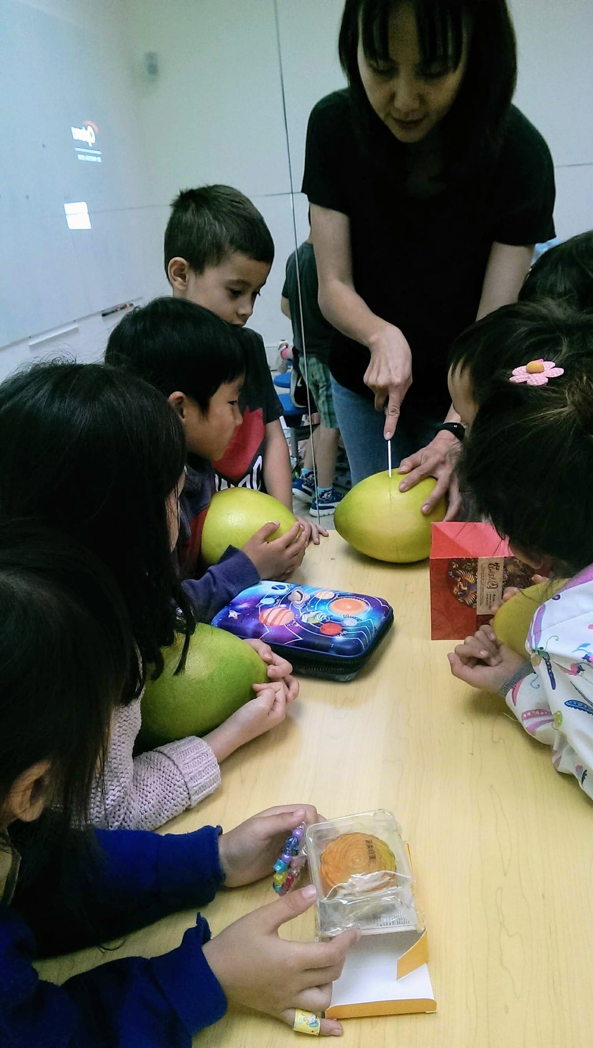 低年級的小朋友年紀還太小，由老師示範怎們“殺柚子”，大家看得津津有味！