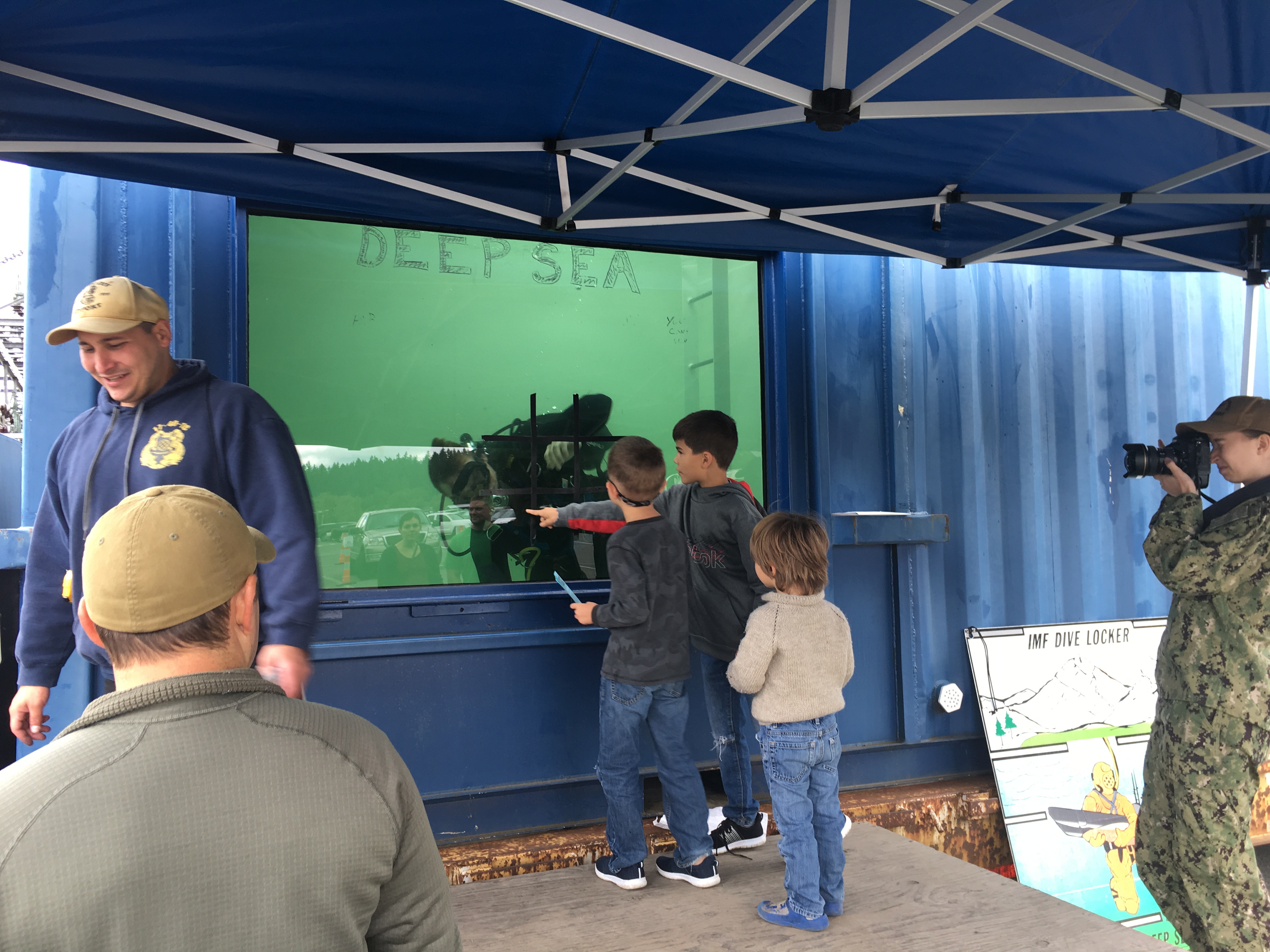 海軍官兵模擬深海潛水與水箱外小朋友大玩遊戲，展現親民作風