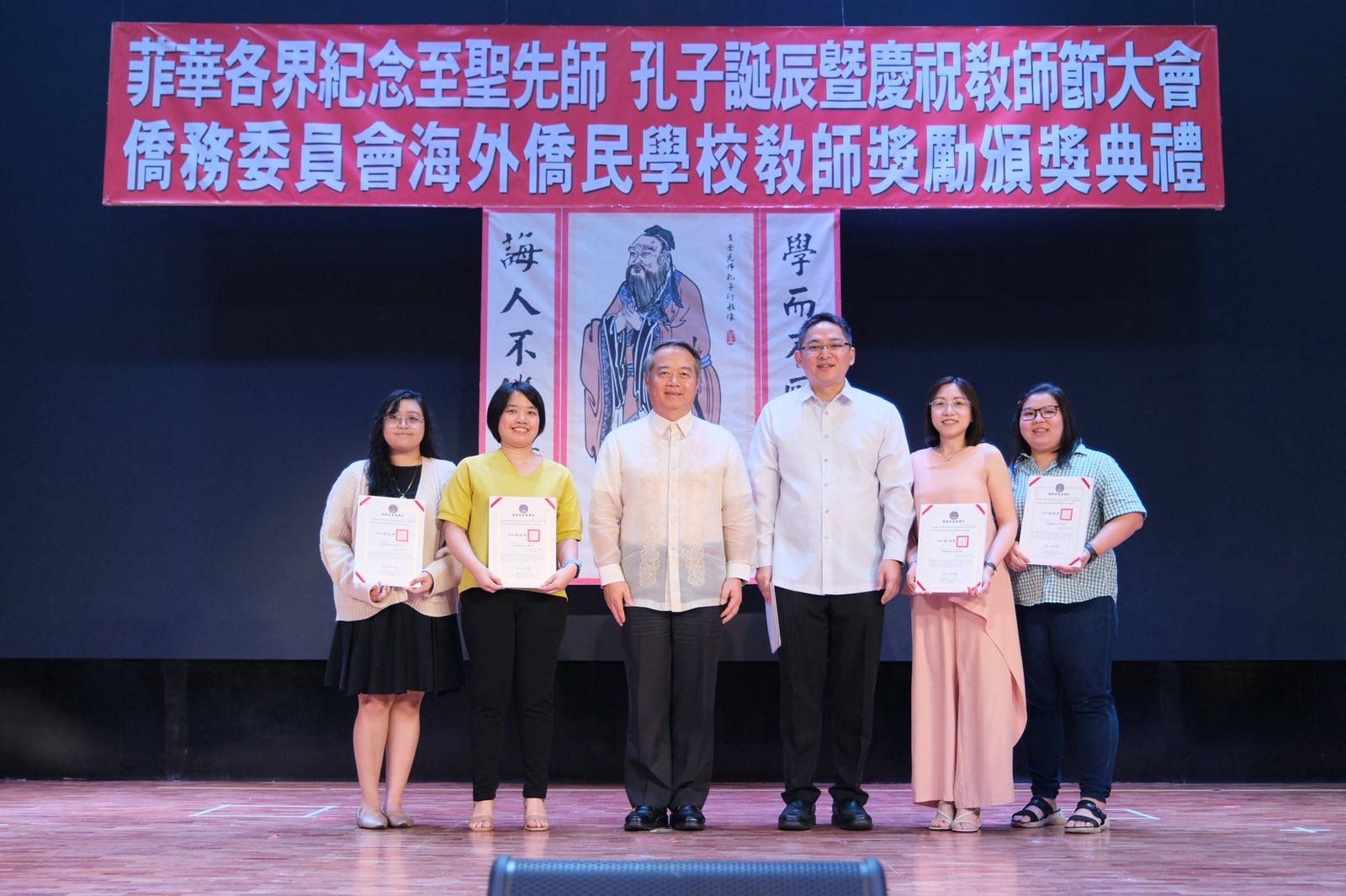 大使周民淦頒贈獎座給執教資深優良教師，菲華文教服務中心主任莊博智同臺見證