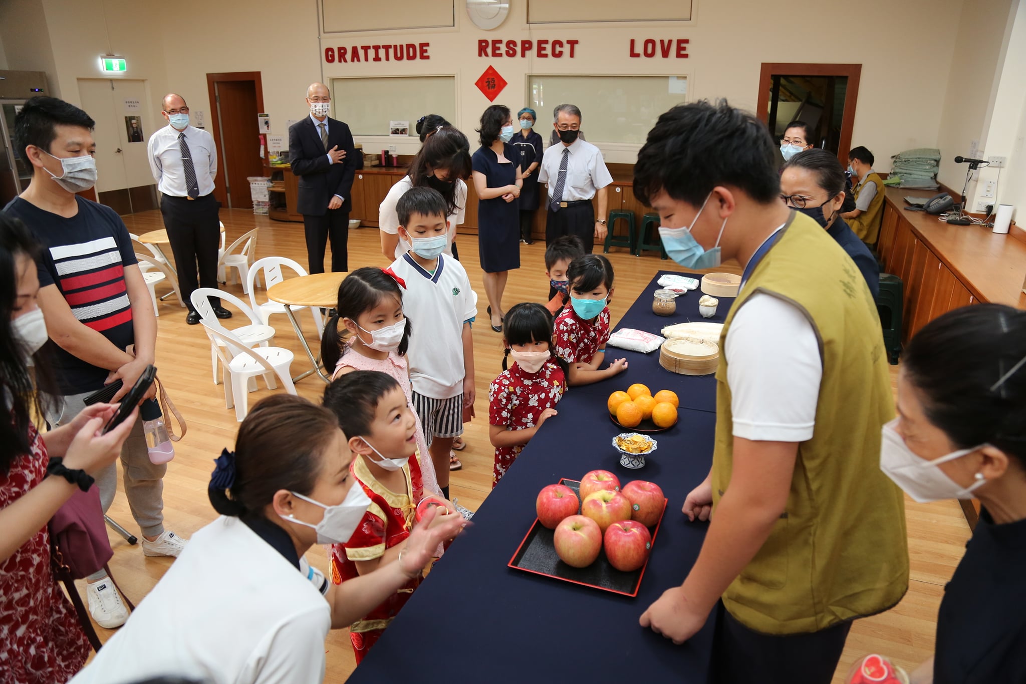 志工向小朋友解說過年使用蘋果、橘子、年糕的意義