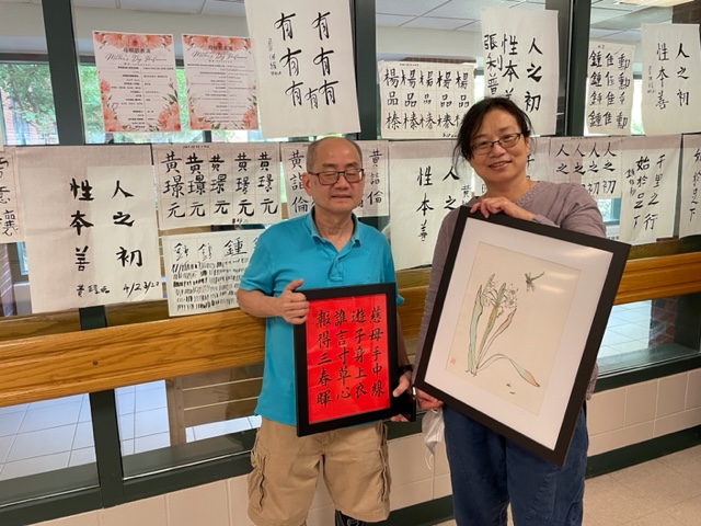 書法老師黃明嘉(左)和國畫老師蔡宜芸(右)各拿著這次個人展出的作品