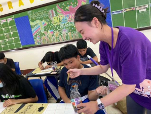 學生帶著塑膠手套試著把分岔的毛筆頭捏尖