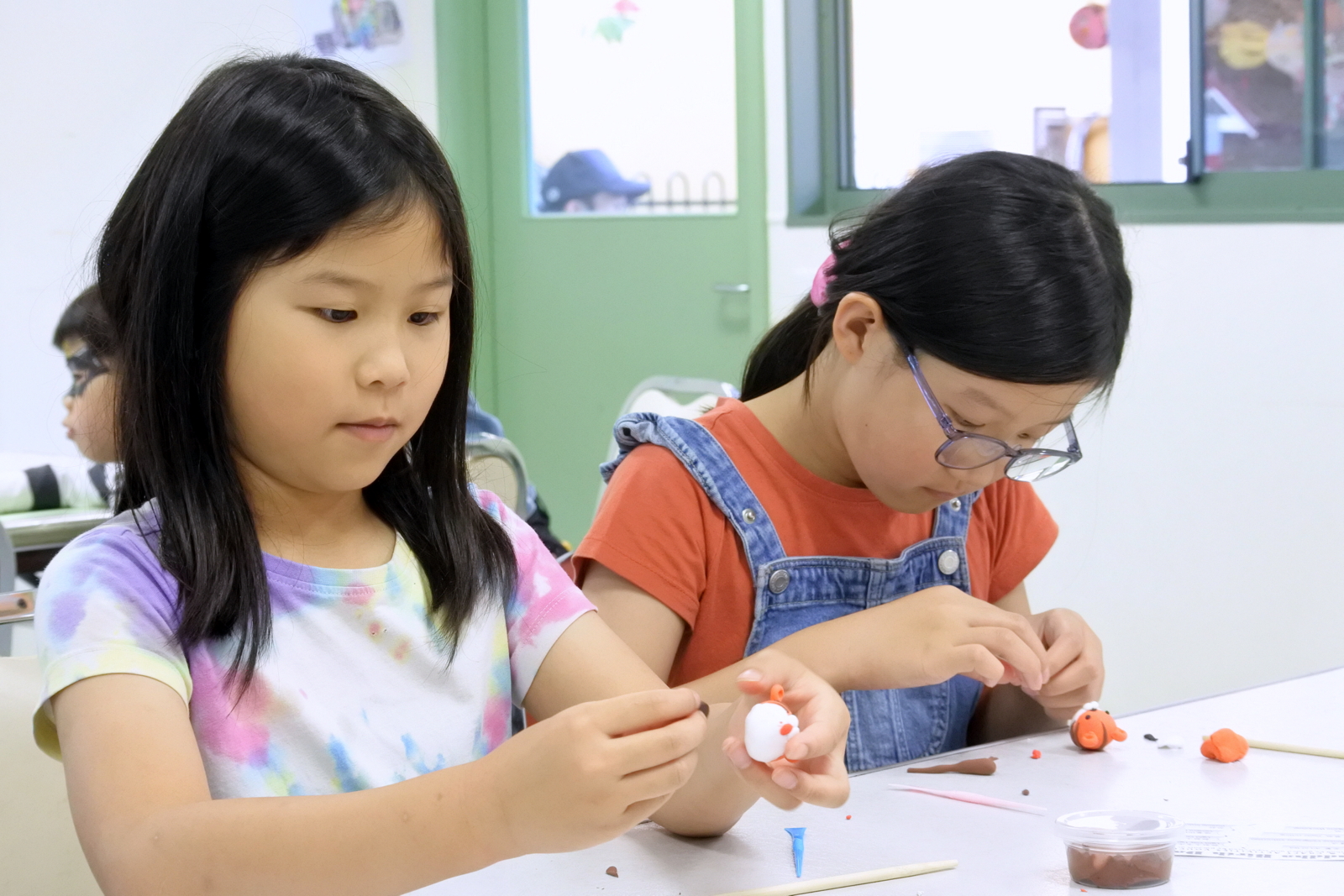 孩子專心製作輕黏土小老虎。