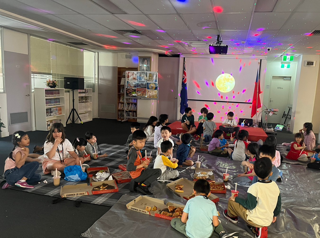 學生席地而坐吃披薩賞月