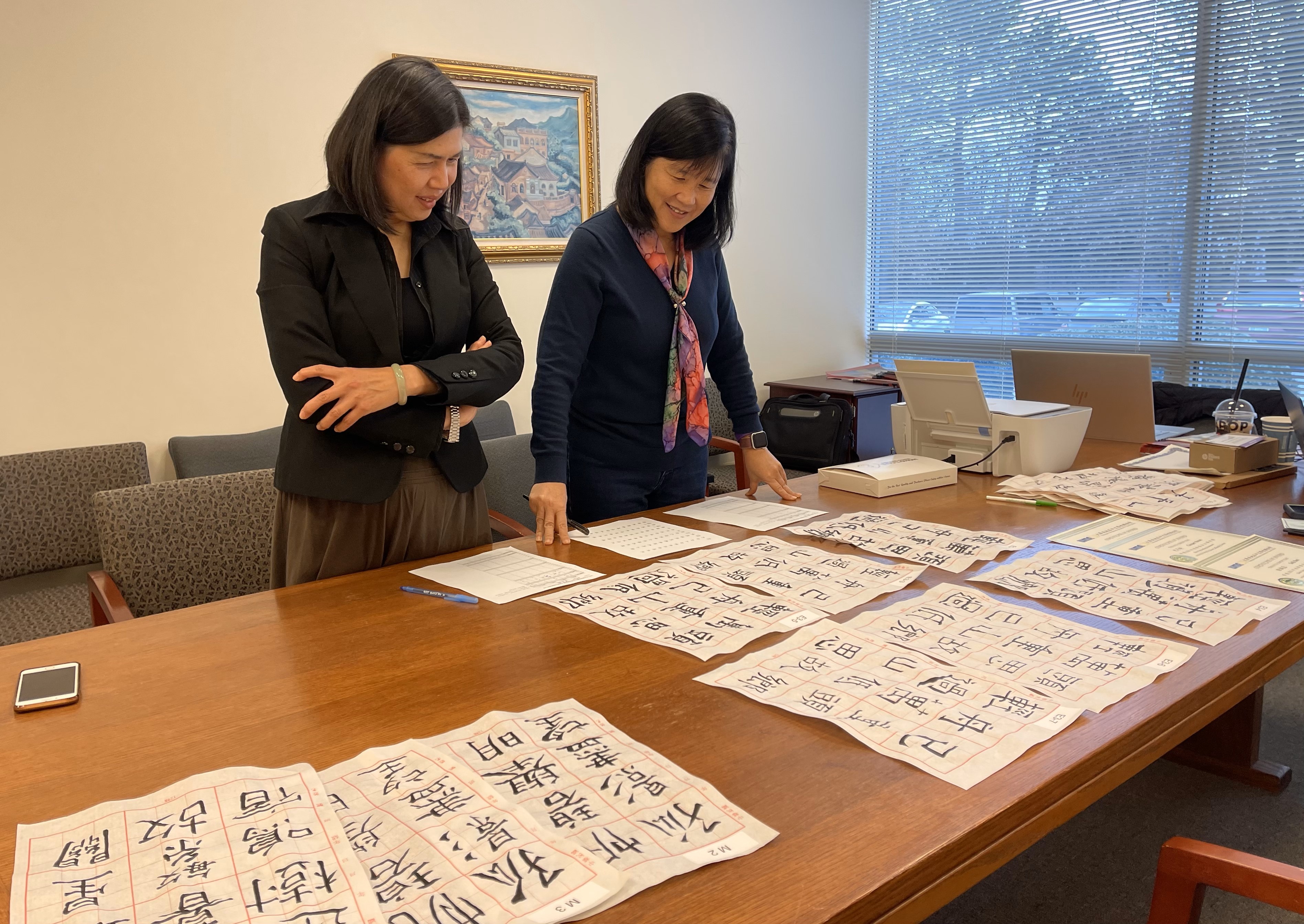 兩位書法老師仔細評鑒學生作品