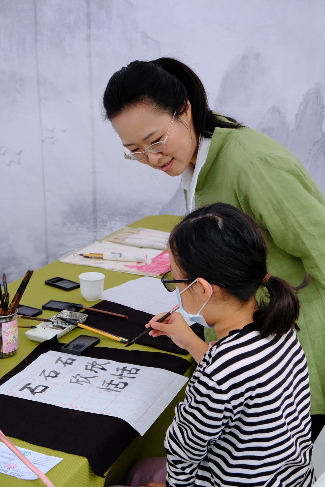 老師指導孩子寫書法。