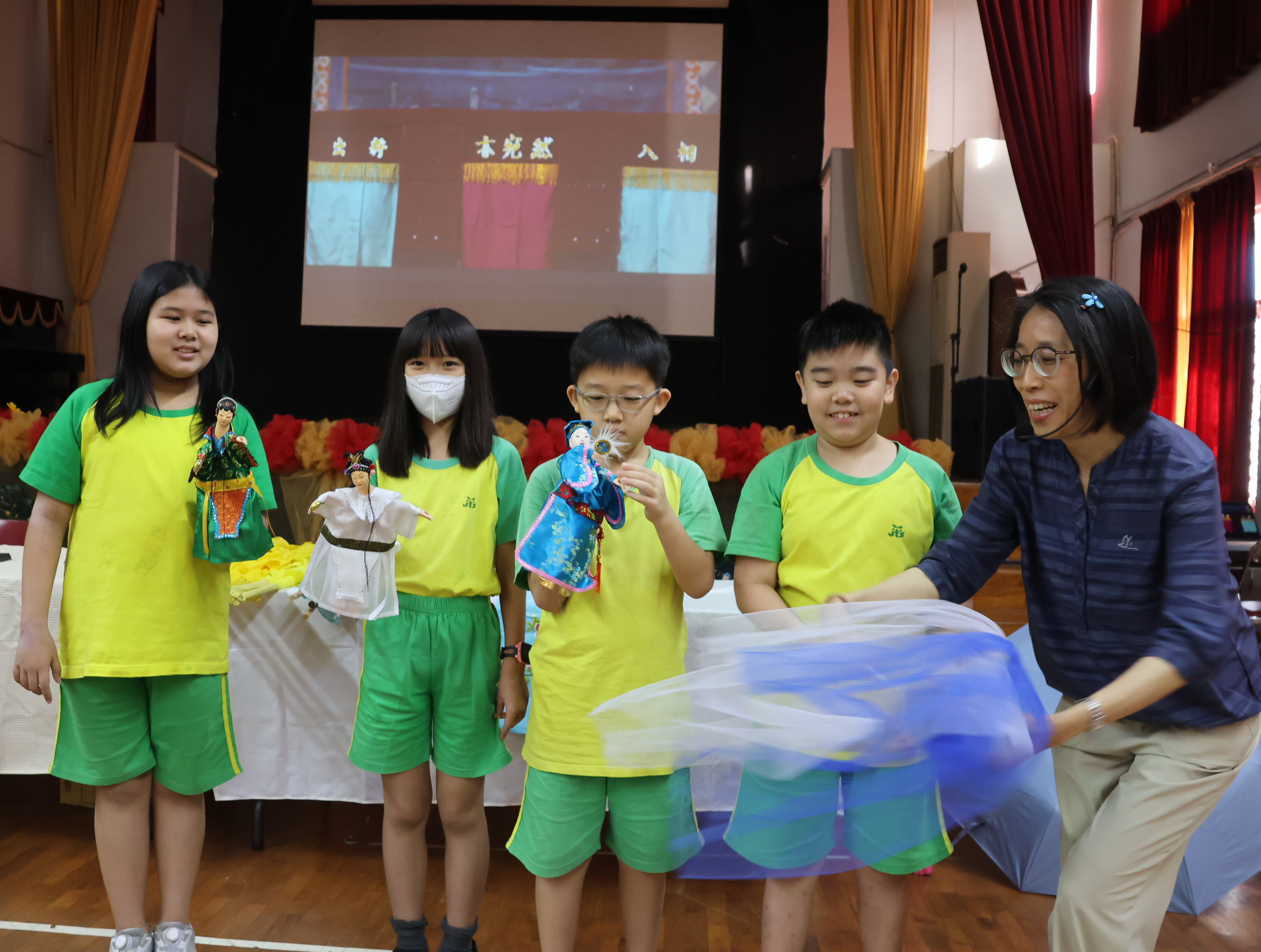 林佳儀教授(右一)指導小學部學童舞弄布袋戲金光布猶如水波盪漾