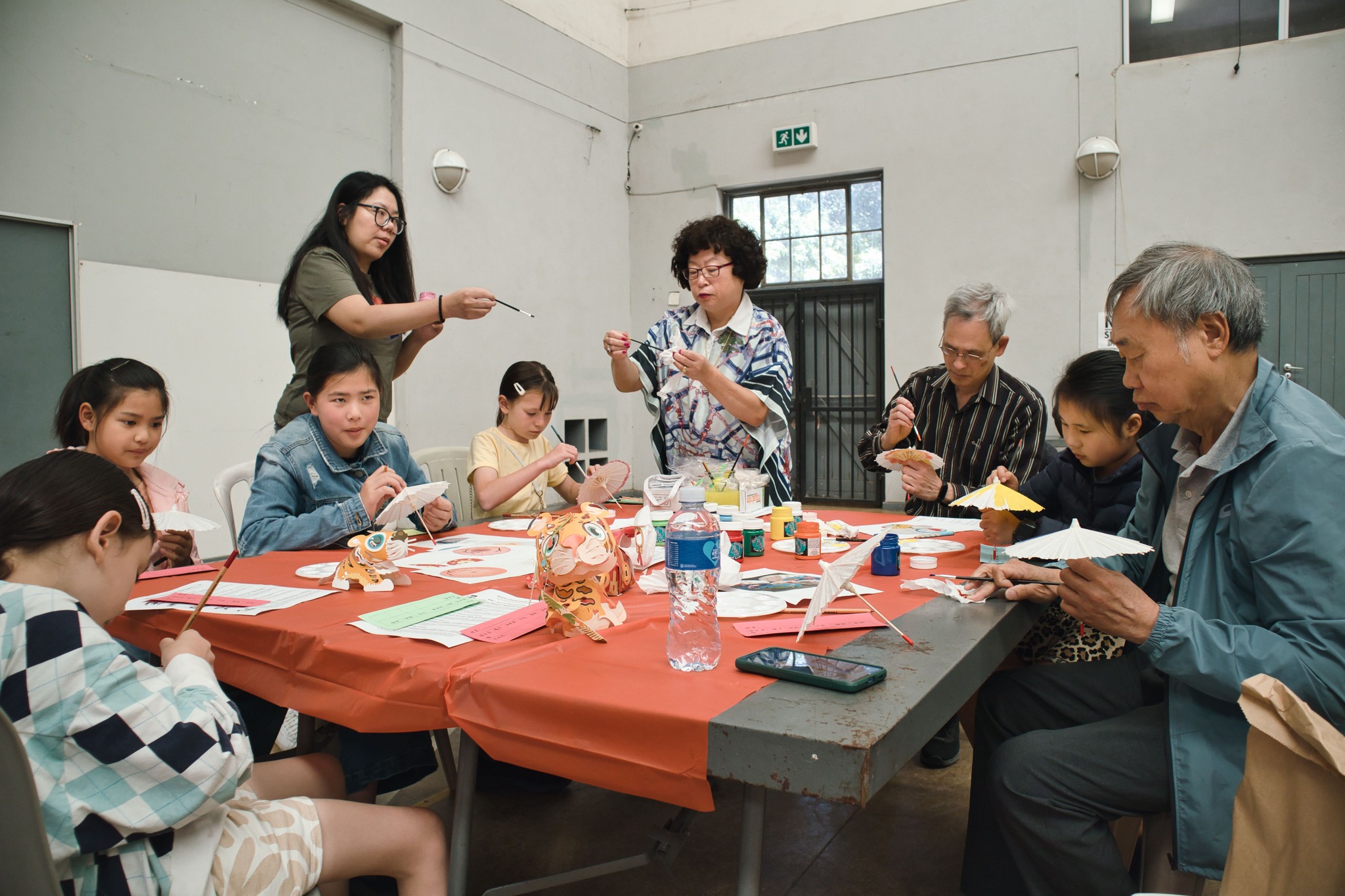 聚精會神彩繪油紙傘，姜依莉(站立者)及章如軍(右)