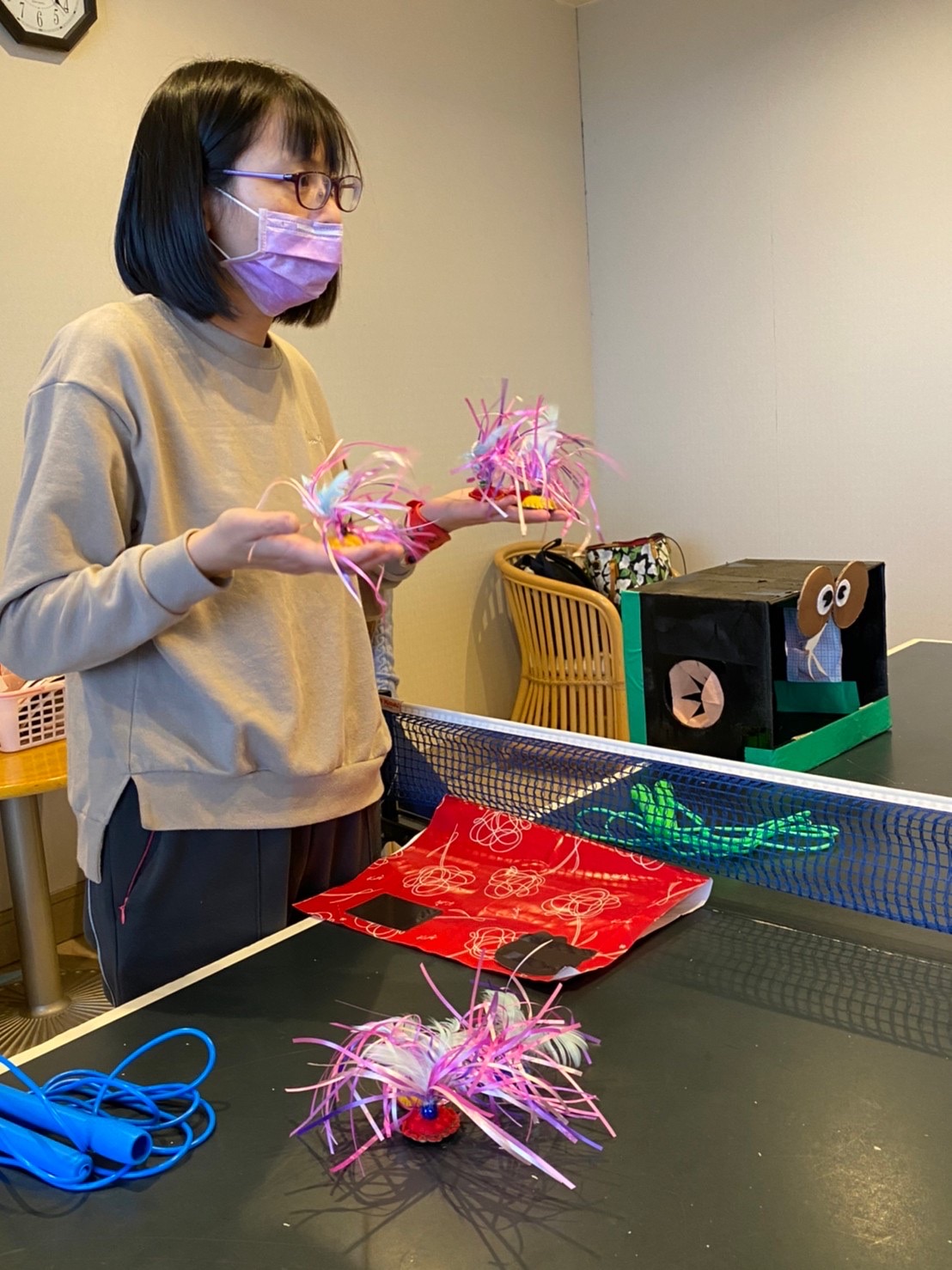 其中一位老師在「摸摸樂」遊戲結束後 向小朋友們解釋台灣的童玩，「毽子」、「跳繩」與「扯鈴」。