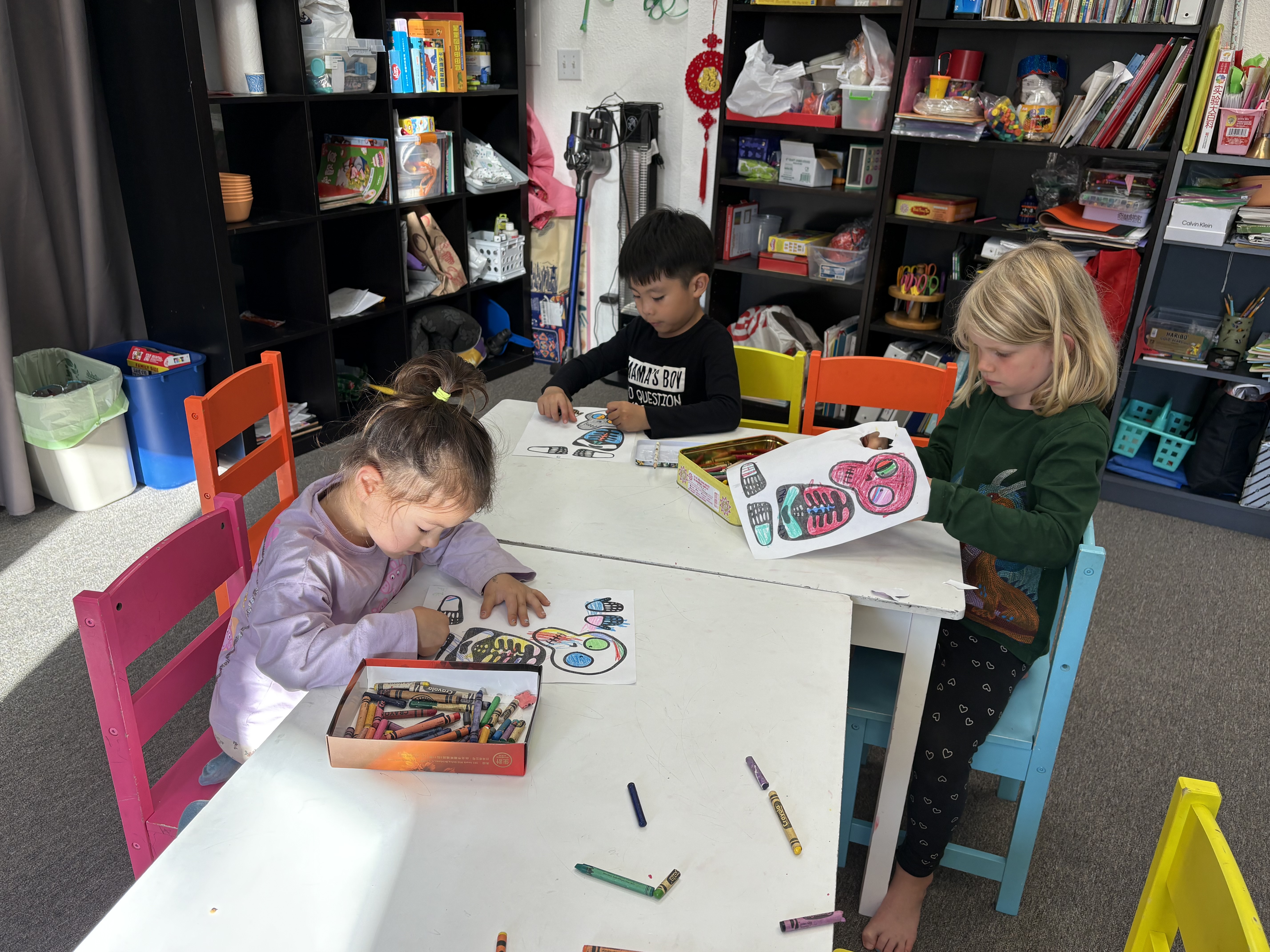 小朋友專注地繪製卡通骷髏頭。