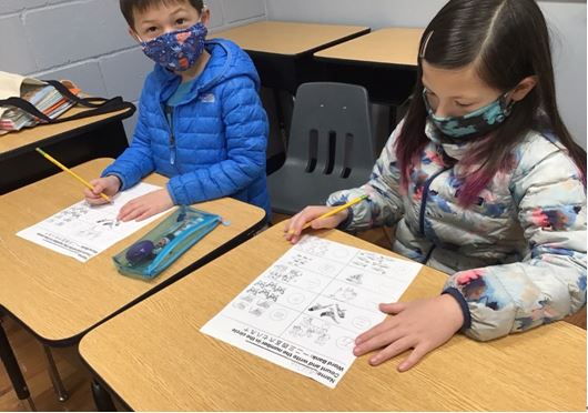 五年級班學生用心在老師出的試卷上作答