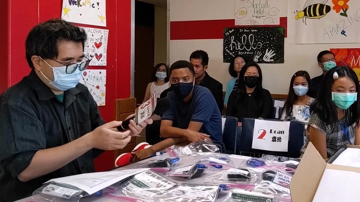 家長陳智暐先生忙著為參賽歌手進行麥克風消毒、麥克風套更換、以及麥克風名牌張貼。